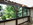 Schiebeverglasung braun auf Terrasse mit Brüstung und Lamellendach